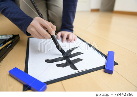 書き初めをする中学生 73442866