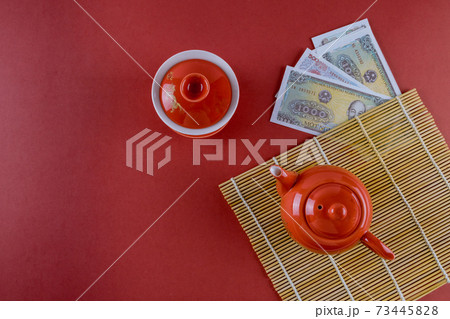 Celebrate Asian festival decorations Vietnamese New Year festive ceremony tea with Money Vietnamese dong on red background Celebrate Asian festival decorations Vietnamese New Year festive ceremony tea with Money Vietnamese dong on red background 73445828