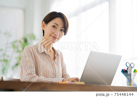 リビングでテレワークをしているミドル女性。 73446144