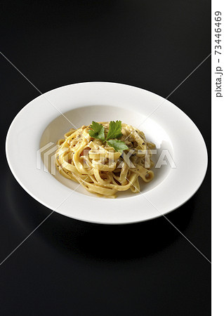 三つ葉が乗っているトリュフクリームの平打ちパスタを黒背景で撮影 三つ葉が乗っているトリュフクリームの平打ちパスタを黒背景で撮影 73446469