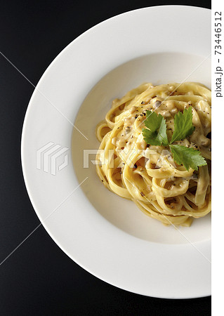 三つ葉が乗っているトリュフクリームの平打ちパスタを黒背景で撮影(俯瞰) 三つ葉が乗っているトリュフクリームの平打ちパスタを黒背景で撮影(俯瞰) 73446512