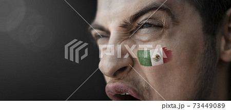 A screaming man with the image of the Mexico national flag on his face A screaming man with the image of the Mexico national flag on his face 73449089