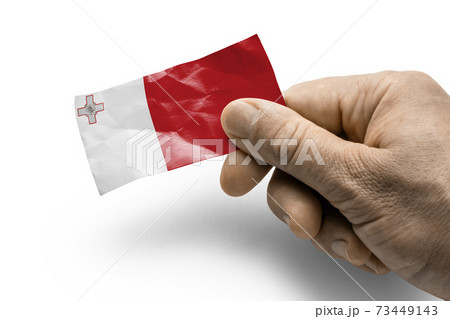 Hand holding a card with a national flag the Malta 73449143