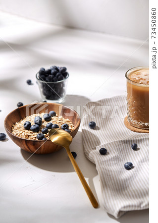 oatmeal with blueberries, spoon and coffee 73450860