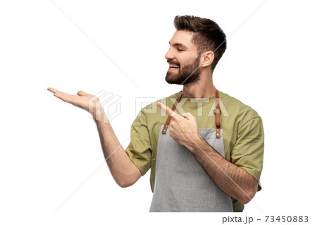 happy barman in apron holding something imaginary 73450883