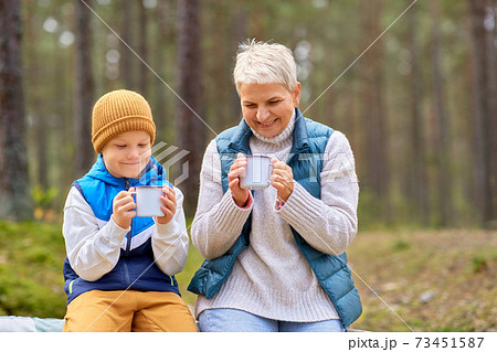 grandmother with grandson drinking tea in forest grandmother with grandson drinking tea in forest 73451587