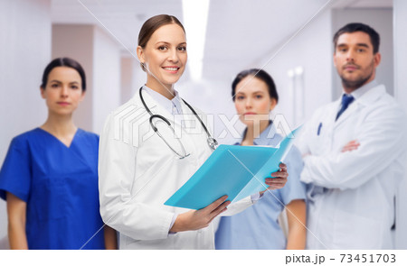 smiling female doctor with colleagues at hospital 73451703