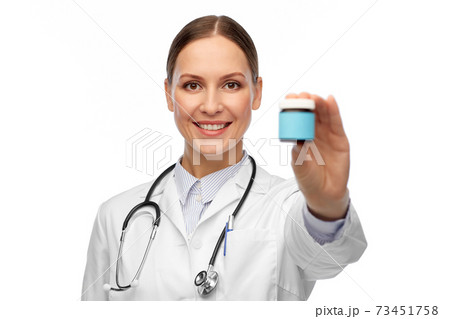 smiling female doctor holding jar of medicine 73451758