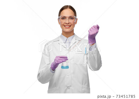 female scientist in goggles with chemical in flask female scientist in goggles with chemical in flask 73451785