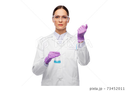 female scientist in goggles with chemical in flask 73452011