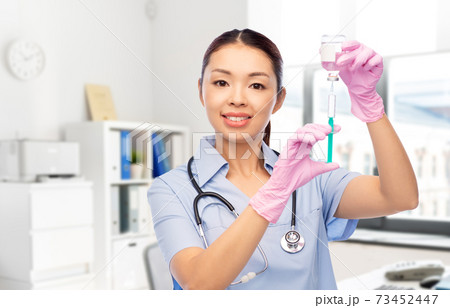 happy asian female nurse with syringe at hospital happy asian female nurse with syringe at hospital 73452447