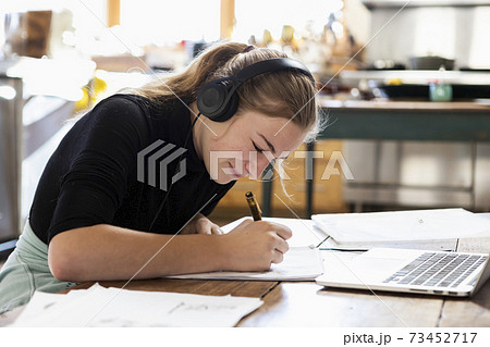 teenage girl wearing headphones, drawing on paper 73452717