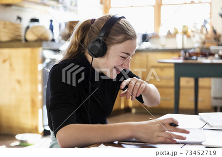 teenage girl wearing headphones, drawing on paper 73452719
