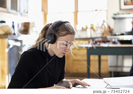 teenage girl wearing headphones, drawing on paper 73452724