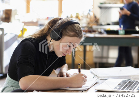 teenage girl wearing headphones, drawing on paper 73452725