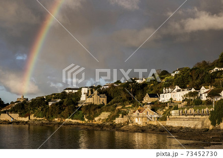 Cloudy sky with rainbow over Saint Mawes, Cornwall, UK. 73452730