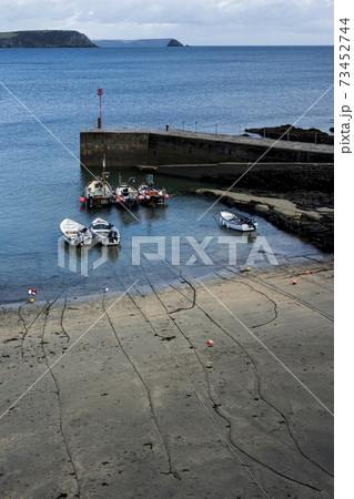 High angle view of fishing boats moored in harbour at low tide. 73452744