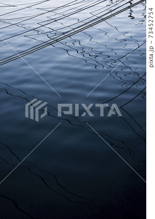 High angle close up of mooring lines and their shadows on the water surface. 73452754
