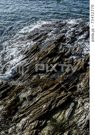 High angle view of waves washing around a rocky shore. 73452770
