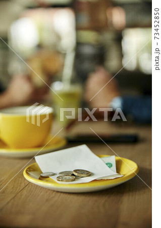 Coins and bill on cafe table 73452850