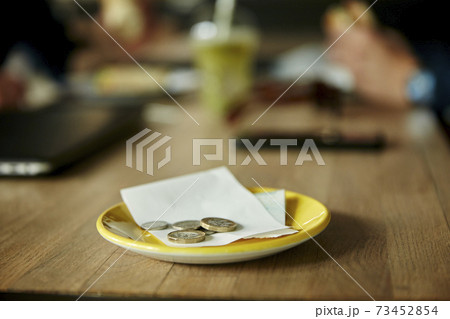 Coins and bill on restaurant table 73452854