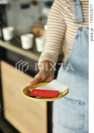 Cafe waitress holding plate with bill and credit card. 73452877