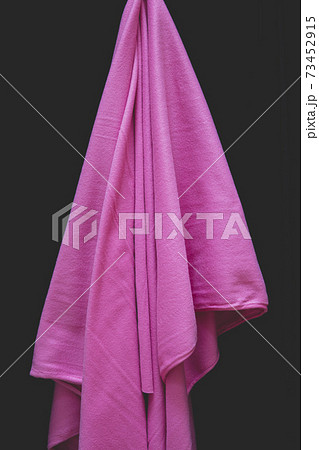 Detail of draped pink fleece fabric against black background 73452915
