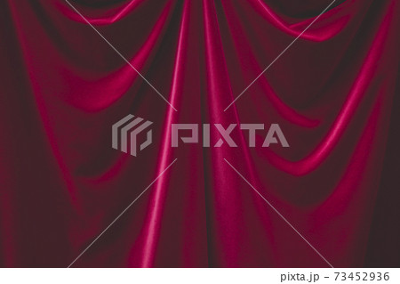 Detail of draped red velvet curtain with folds and creases 73452936