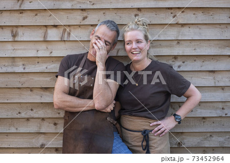 Man and woman in aprons, colleagues taking a break from work, laughing 73452964