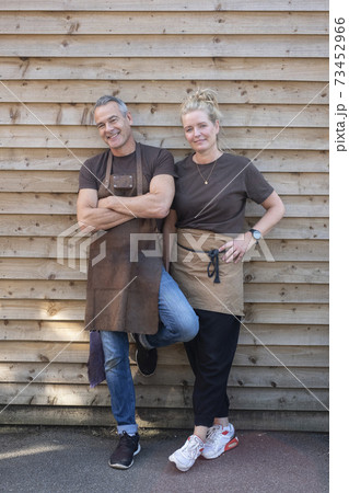 Man and woman in aprons, colleagues taking a break from work, laughing 73452966
