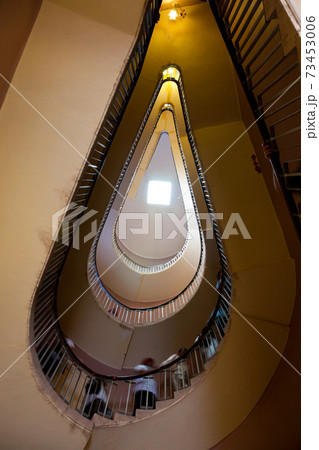 People ascending a spiral stair, view from below. 73453006