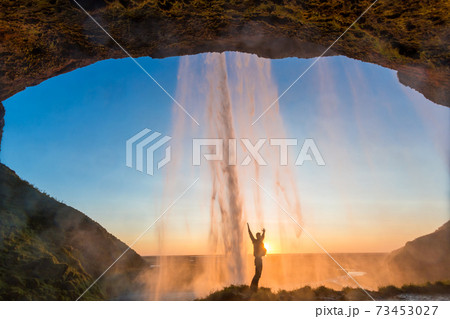 Man behind Seljalandsfoss Waterfall, South Iceland, Iceland Man behind Seljalandsfoss Waterfall, South Iceland, Iceland 73453027