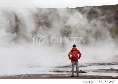 Woman standing by geothermal pools, South West Iceland 73453047