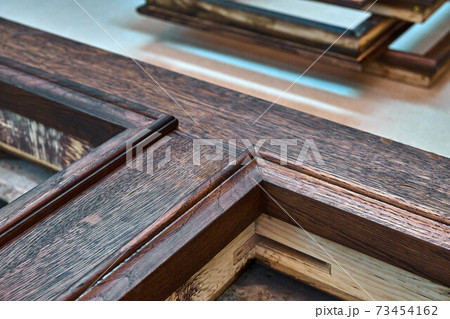 Joinery. Door frame with wooden moldings, painted in dark color. Wood door manufacturing process. Furniture manufacture 73454162