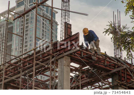 Construction Worker Welding soldering metal girders and Sparks. 73454643