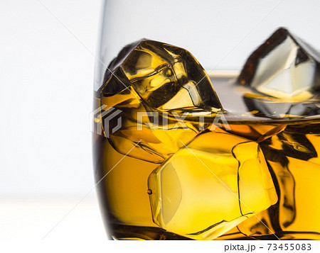 Whisky on the rocks on white background 73455083