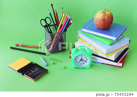 School stationery, books, alarm clock on desk, home learning concept, back to school 73455294