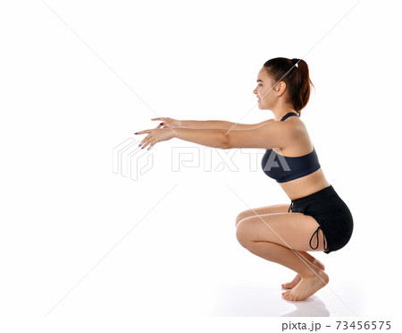 Studio shot woman doing squats on white copy space 73456575
