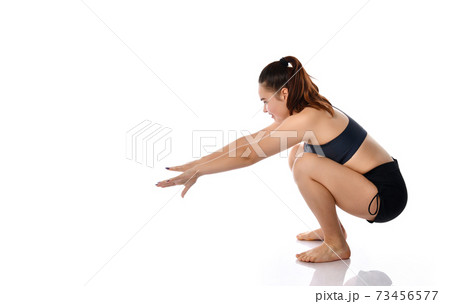 Woman gets up after squatting studio shot on white 73456577