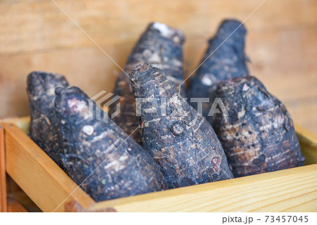 Taro root ready to cook, Raw organic brown taro on wooden table. 73457045