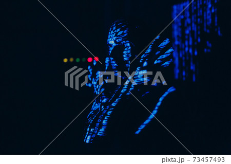 Young man with blue letters on his face in the dark. Young man with blue letters on his face in the dark. 73457493