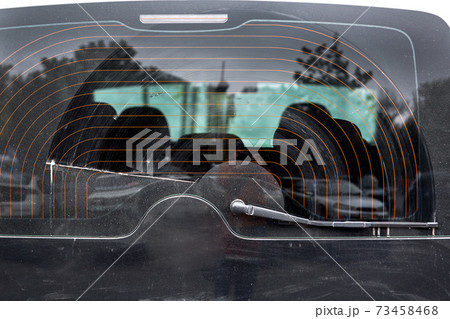 dirty car glass in a layer of dust wiped by a wiper, close up of the rear window of the heated black car. dirty car glass in a layer of dust wiped by a wiper, close up of the rear window of the heated black car. 73458468