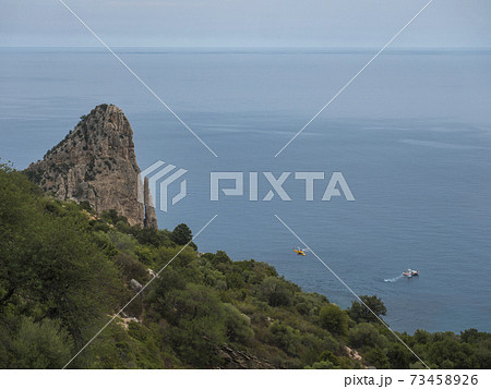 View of Pedra Longa, limestone rock pillar at coast Gulf of Orosei with rescue boat and chopper. Sardinia, Italy View of Pedra Longa, limestone rock pillar at coast Gulf of Orosei with rescue boat and chopper. Sardinia, Italy 73458926