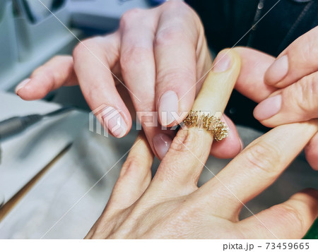 Closeup of a girl's hands in a nail salon. piral for finger massage. Closeup of a girl's hands in a nail salon. piral for finger massage. 73459665