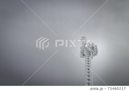 Spectacular communication tower frozen under white sky 73460217