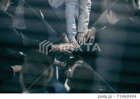 through the blinds. business team showing their unity. 73460494