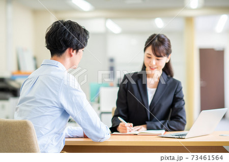 ビジネスウーマンに相談する若い男性 73461564
