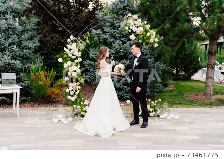 wedding ceremony in arch of living flowers. bride says wedding vow and cry 73461775