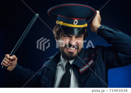 a man in a Russian police uniform with a baton. English translation of " Police" 73463036