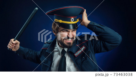 a man in a Russian police uniform with a baton. English translation of " Police" 73463038